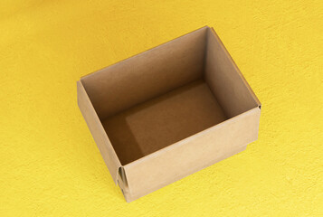 Empty open cardboard boxes on yellow background