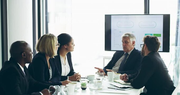Confident senior leader, manager or boss talking to employees and staff, discussing performance. Group or team of business people meeting in a boardroom, planning and thinking of marketing strategy