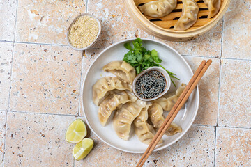 Dumplings gyoza jiaozi steamed  on a white plate with soy sauce. Takeout  food