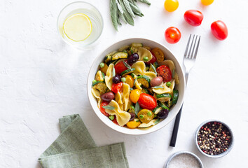 Pasta farfalle with tomatoes, zucchini, peas, Kalamata olives and sage. Healthy eating. Vegetarian food.