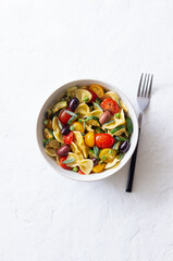 Pasta farfalle with tomatoes, zucchini, peas, Kalamata olives and sage. Healthy eating. Vegetarian food.