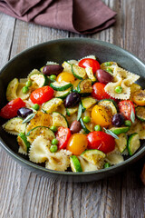 Pasta farfalle with tomatoes, zucchini, peas, Kalamata olives and sage. Healthy eating. Vegetarian food.