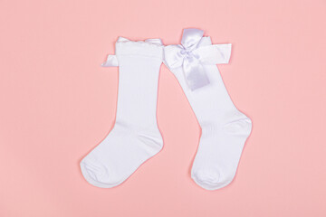high white children's socks for girls with big bows for party wear on a pink background