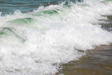 Fototapeta premium Splashes of fresh foaming, bubbling sea water, mad whirlpool waves, white crest of waves, Sandy coast of Baltic Sea, Poland.