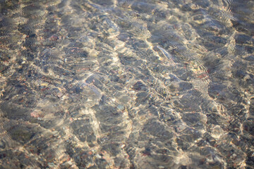 Sun reflections in cristal clear Baltic waters. Water texture - wave pattern, gentle wind ripples on surface.