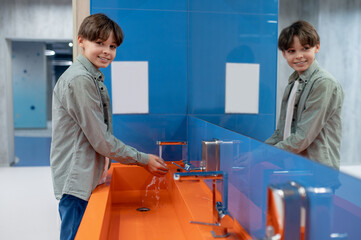 A boy washing hands in a school toilet