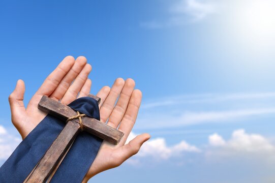 Human hand holding wooden cross crucifix. Catholicism, Christianity, Thanksgiving, Catholic and Christian faith concept.