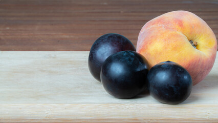 Peach and plum on a wooden board close-up of fruit
