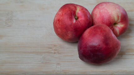 Nectarine fruits three pieces on a wooden background with a place for inscription