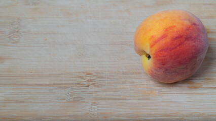 Peach fruit on a wooden background with space for text