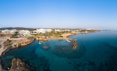 Aerial bird's eye view of Green bay Protaras, Paralimni, Famagusta, Cyprus. Famous tourist attraction diving location rock beach with boats, sea restaurant, water sports on summer holidays, from above
