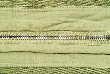 Abstracr zipper line on green cloth background.