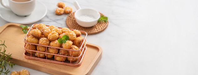 Delicious French Chouquette Choux Pastry dessert Pearl Sugar Puff on white marble background.