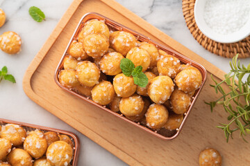 Delicious French Chouquette Choux Pastry dessert Pearl Sugar Puff on white marble background.
