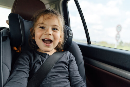 Delighted little child singing in car during trip