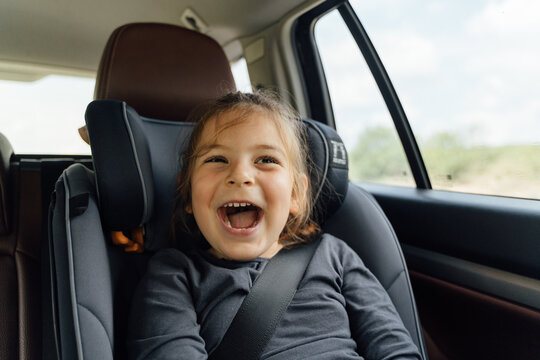 Delighted little child singing in car during trip