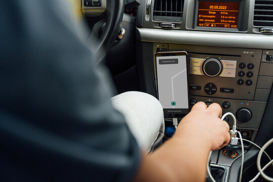 Anonymous male with navigator on mobile phone driving car