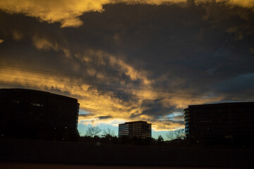 dramatic ominous storm clouds form at sunset over office buildings 