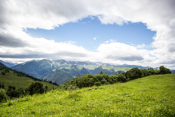 Fototapeta na wymiar Green meadow and mountain landscape. Summer in the mountains