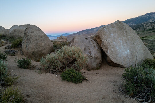 wide sunset view with pink sky of boulders in Buttermilks, Bishop, CA