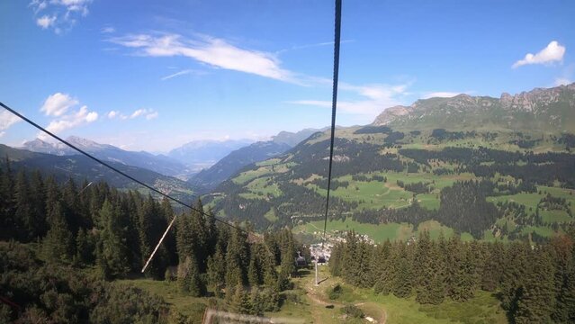 Cable car ride in the canton of Grisons. View of beautiful nature in Switzerland from a cable car. The ropeway descends into the valley