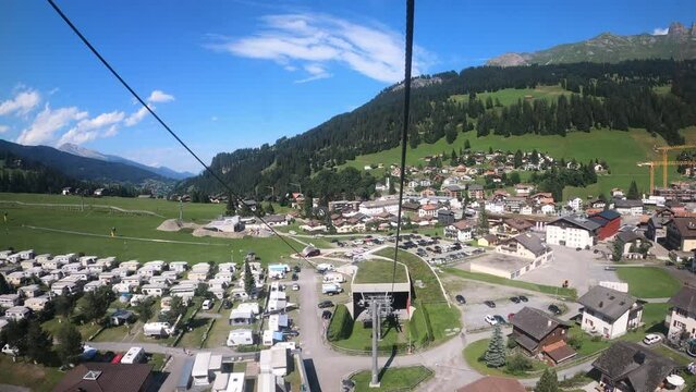 Cable car ride in Switzerland. The cable car descends into the valley. You can see the campsite in the village and the beautiful nature of Switzerland with its hiking trails. Grisons Churwalden