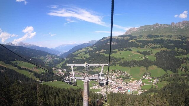Cable car ride in canton Grisons Churwalden. The gondola lift descends into the valley. The small village in the valley can be viewed.