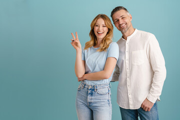 White happy couple smiling and showing peace gesture