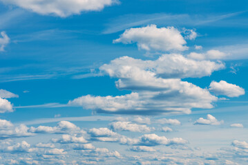 Fototapeta premium White clouds in the blue sky. White light cloudy heaven,good weather. Summer sky. Heaven and infinity. Curly clouds on a sunny day. Beautiful bright blue background.