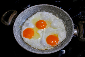 fried eggs in a frying pan, top view.