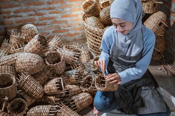 close up of craftswoman in veil weaving water hyacinth crafts in a brick house