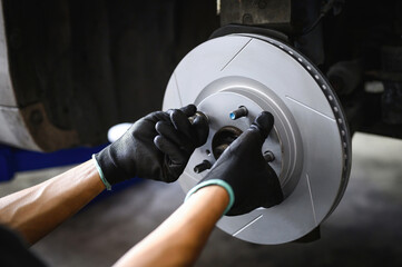 Auto mechanic installing a new six slot brake rotors.