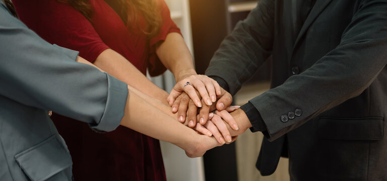 Teamwork business concept of group of three coworkers join hand together during their meeting..