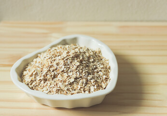 oat or granola in heart shape white bowl, ready for cooking. Healthy food  concept.