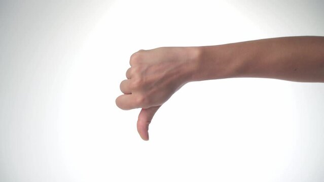 A women's hand shows dislike, thumb down on a white background