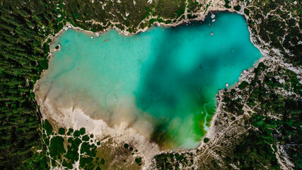 Lago di Sorapiss from above,beautiful mountain lake in Dolomite Alps,Italy.Turquoise color water is dust from the glacier.crystal clear water top down view.Drone nature,alpine forest