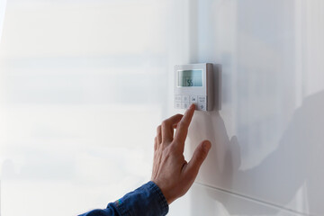 The air conditioning and heating control panel for the apartment and office is located on a white wall.