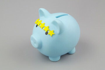 Blue piggy bank with 5 rating stars on gray background. Good way to save money concept.	