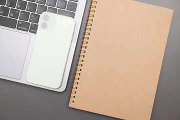Gray desk office with laptop, smartphone and other work supplies. computer desk with keyboard, smartphone and stationery. copy space for input the text.