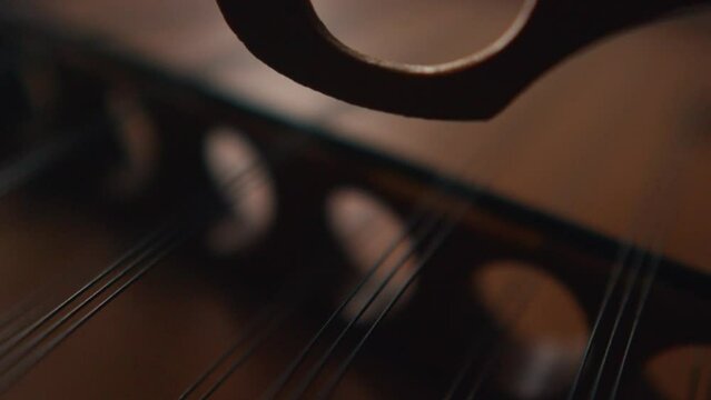 hammering dulcimer string, extremely close up slow motion of classic traditional musical instrument