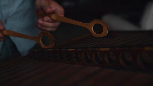 skilled male hands hammering dulcimer strings with wooden stick extreme close up slow motion
