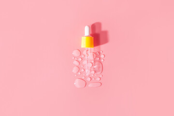 Yellow pipette transparent drops of serum moisturized bottle on pink background. Essence hyaluronic acid close up. Spa, beauty, skincare product.
