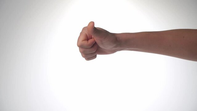 women's hand shows dislike it, thumb down on a white background