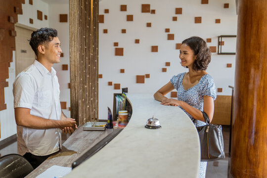 Female Guest Comes And Checks In With The Hotel Receptionist In The Lobby