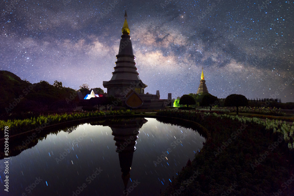 Wall mural the milky way galaxy moving over a sacred temple at doi inthanon national park, chiang mai, thailand
