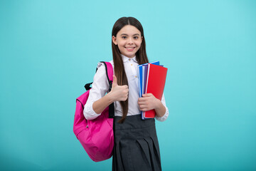 Back to school. Teenager school girl hold book and copybook ready to learn. School children with school bag on isolated blue studio background.
