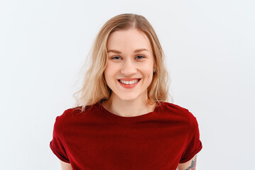 Young emotional woman. Close up portrait of young blonde woman 20s, wearing casual red t shirt. Indoor studio shot on white background. Human emotions, facial expression concept