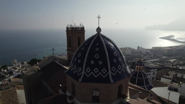 Aerial circle view of the blue cupol of the cathedral overlooking the sea. Altea. Spain