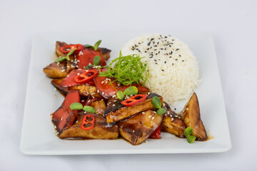 rice with chili pepper chicken and vegetables on a white plate
