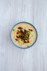 Homemade Corn Chowder with Bacon in a Bowl on a white wooden background, top view. Flat lay, overhead, from above.